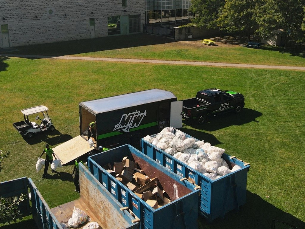 MTW crew with branded truck, trailer, and dumpsters on an event site
